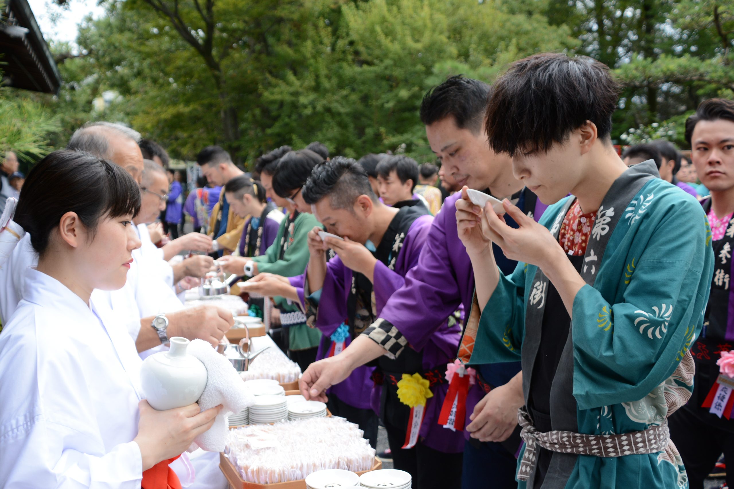 大井神社で青年たちがお神酒をふるまわれている様子